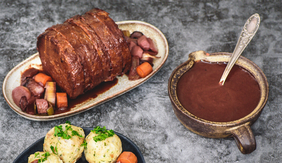 Wheaty-Festtagsbraten als Sauerbraten zubereitet, mit einer Schüssel voll Sauce.